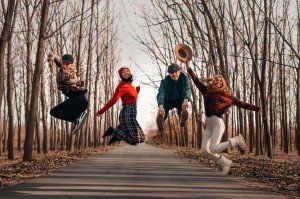 two-men-and-women-jumping-on-roadway-surrounded-by-bare-3373480